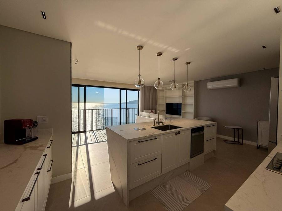 Cozinha gourmet integrada com vista para o mar em apartamento na Meia Praia