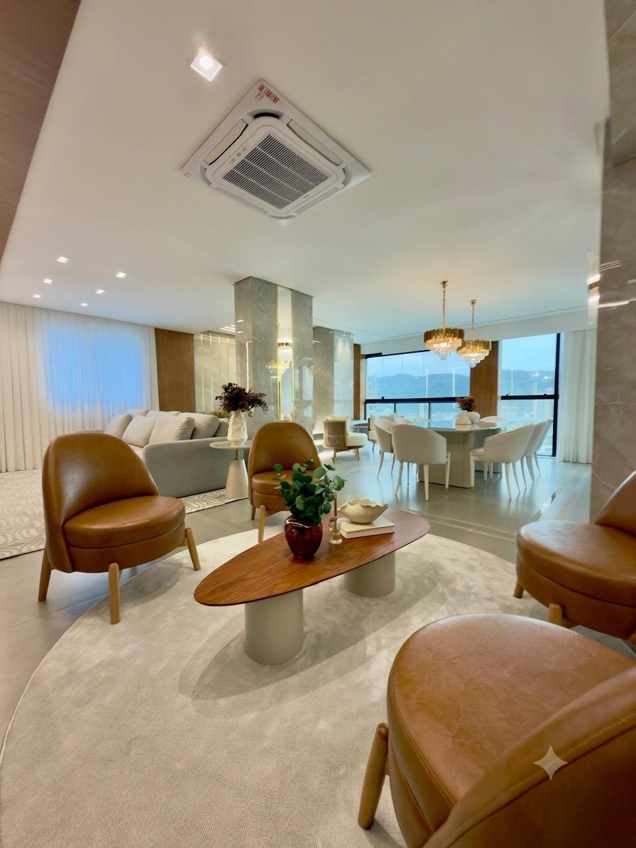 Living integrado com poltronas de design e vista panorâmica em Itapema
